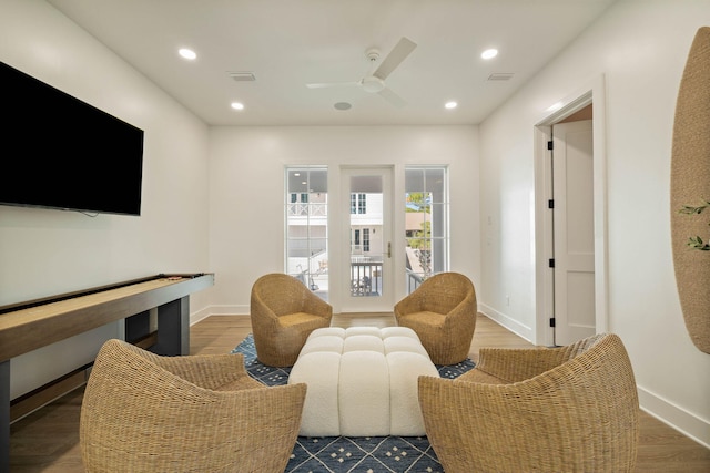 living room featuring wood-type flooring and ceiling fan