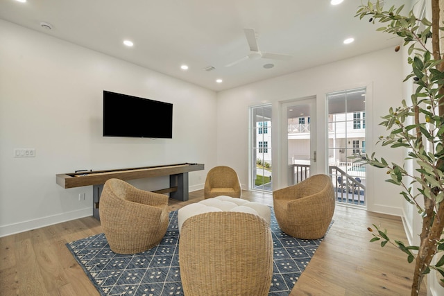 living room featuring light hardwood / wood-style flooring and ceiling fan