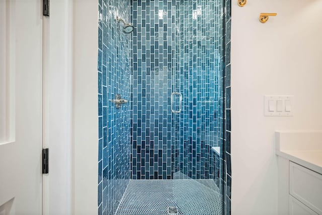 bathroom with a shower with door and vanity