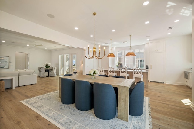 dining room featuring light hardwood / wood-style floors, a healthy amount of sunlight, and a chandelier