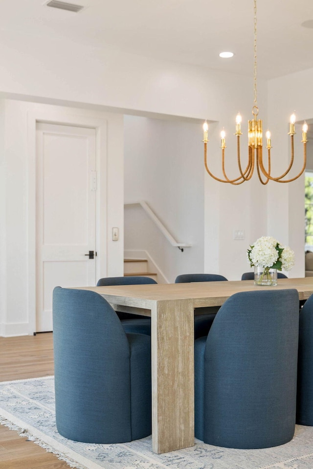 dining space featuring light hardwood / wood-style flooring and a chandelier