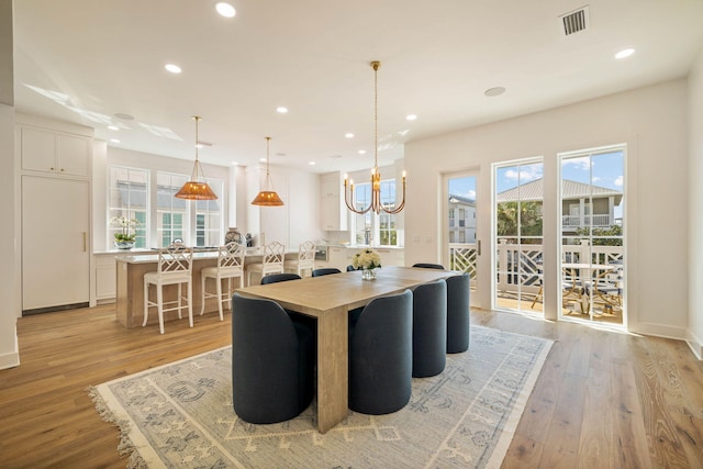 dining space featuring an inviting chandelier and light hardwood / wood-style floors