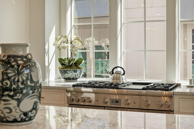 kitchen with stainless steel gas cooktop and light stone counters