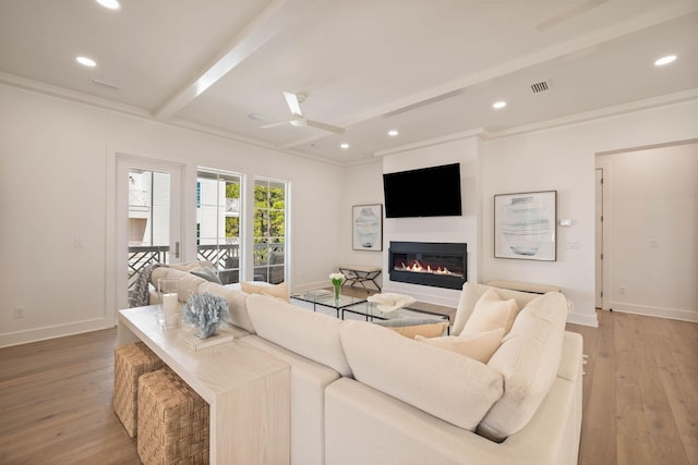 living room featuring ceiling fan, beam ceiling, crown molding, and hardwood / wood-style floors