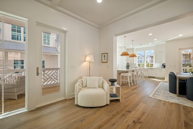 living area featuring light hardwood / wood-style flooring and a chandelier