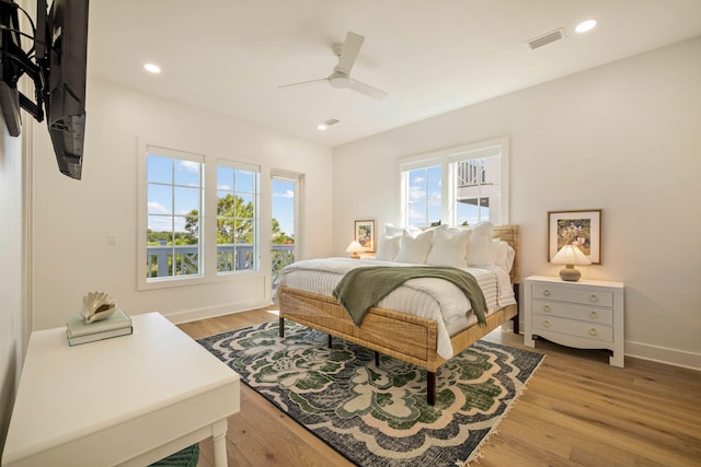 bedroom featuring multiple windows, hardwood / wood-style floors, and ceiling fan