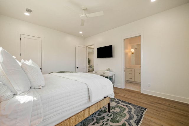 bedroom featuring ensuite bath, hardwood / wood-style floors, and ceiling fan