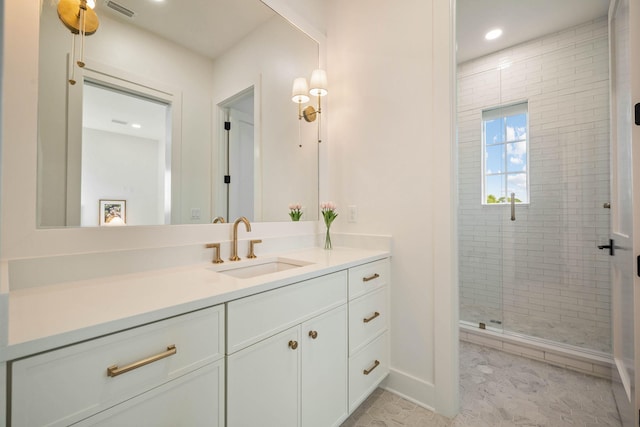 bathroom featuring a shower with door and vanity