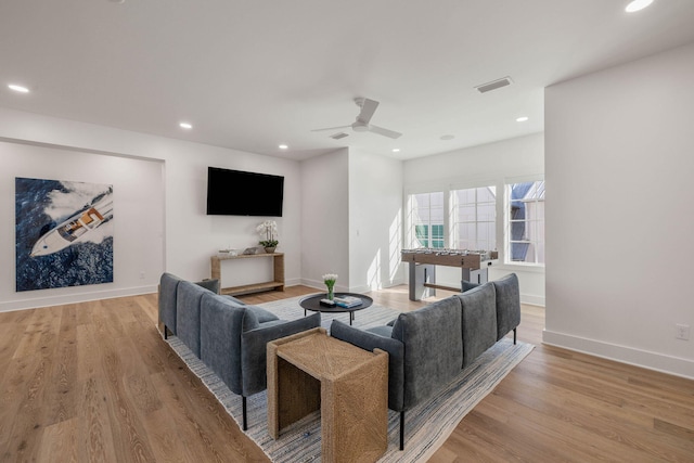 living room featuring light hardwood / wood-style flooring and ceiling fan