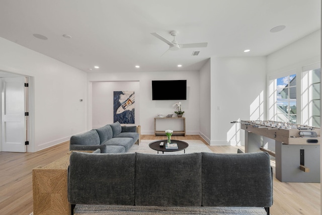 living room featuring light hardwood / wood-style flooring and ceiling fan