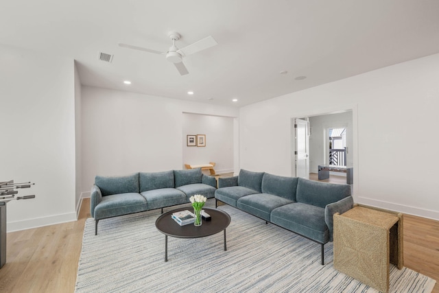 living room with light wood-type flooring and ceiling fan