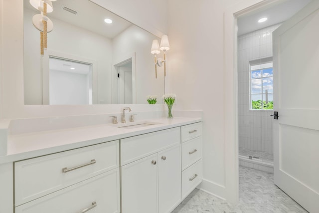 bathroom with vanity and tiled shower