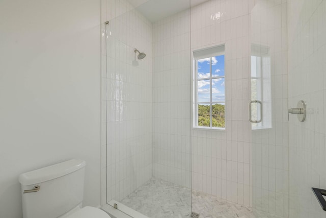 bathroom with a shower with door and toilet