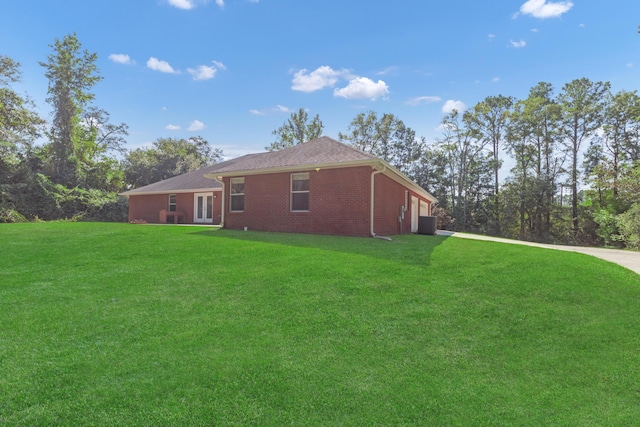 view of side of home with a yard and cooling unit