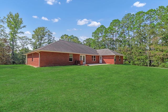 rear view of property featuring a patio area and a lawn