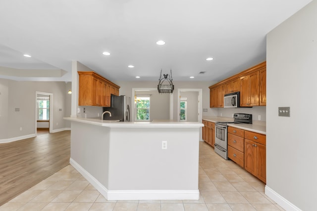 kitchen featuring a healthy amount of sunlight, light tile patterned floors, and appliances with stainless steel finishes