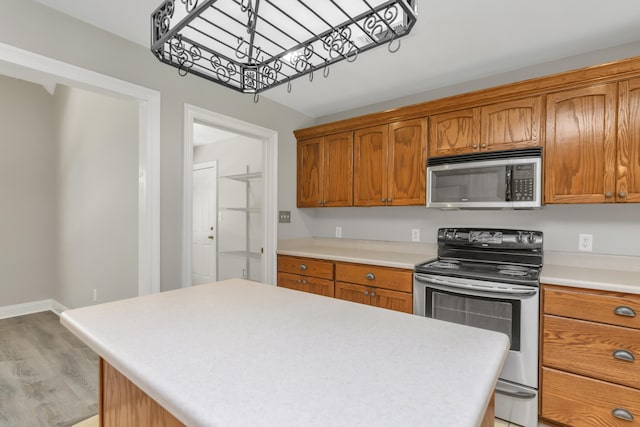 kitchen with a kitchen island, stainless steel appliances, and light hardwood / wood-style flooring