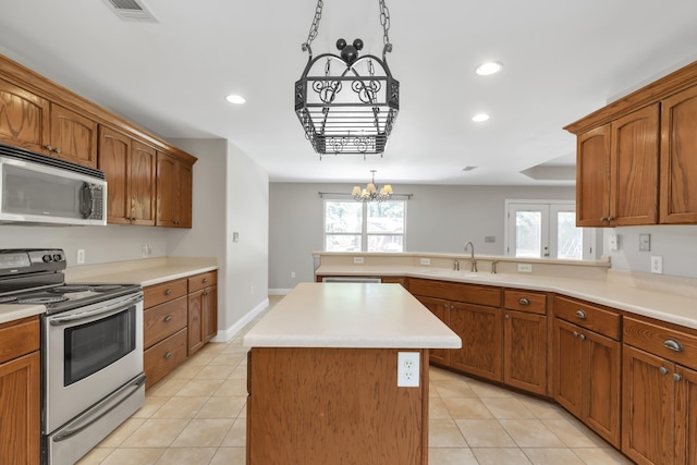 kitchen featuring sink, light tile patterned floors, an inviting chandelier, a kitchen island, and appliances with stainless steel finishes