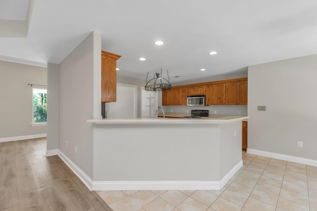 kitchen with kitchen peninsula, black stove, and sink