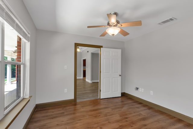 empty room with dark hardwood / wood-style flooring and ceiling fan