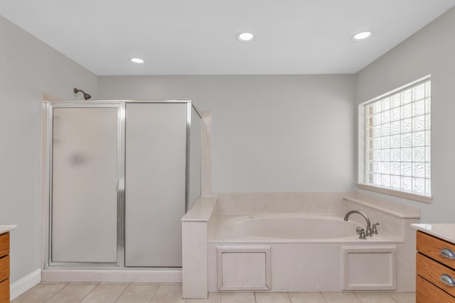 bathroom with shower with separate bathtub, vanity, and tile patterned floors