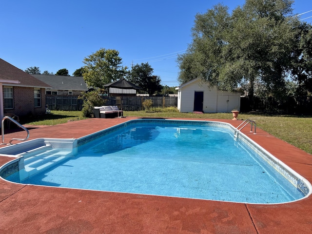 view of pool with an outdoor structure, a lawn, and a fenced backyard