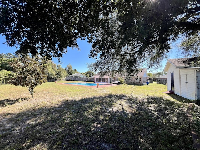 view of yard featuring a fenced backyard, an outbuilding, and an outdoor pool