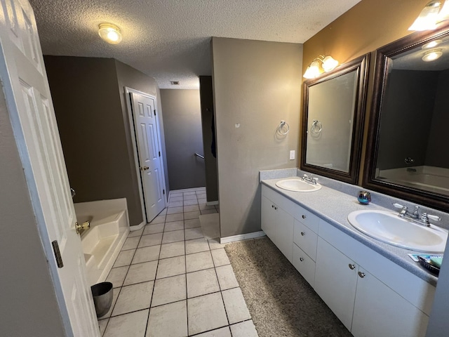 full bath with a textured ceiling, a garden tub, double vanity, and a sink