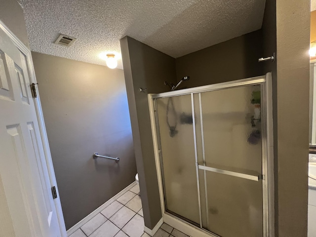 bathroom featuring a shower stall, tile patterned floors, visible vents, and a textured ceiling