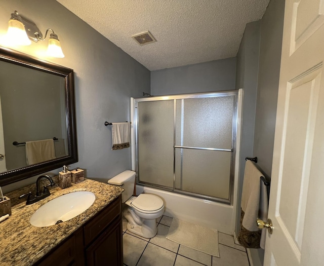 bathroom with toilet, vanity, a textured ceiling, visible vents, and tile patterned flooring