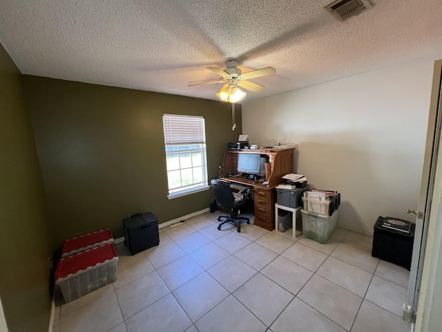 home office with light tile patterned floors, visible vents, a ceiling fan, and a textured ceiling