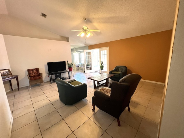 living area with light tile patterned floors, a ceiling fan, visible vents, baseboards, and vaulted ceiling