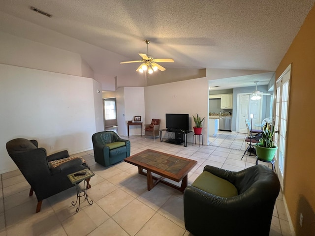 tiled living room featuring vaulted ceiling, a textured ceiling, and ceiling fan