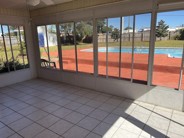 unfurnished sunroom featuring a ceiling fan
