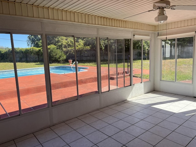unfurnished sunroom featuring ceiling fan