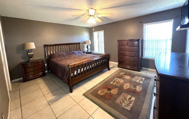 bedroom featuring a textured ceiling, light tile patterned floors, and ceiling fan