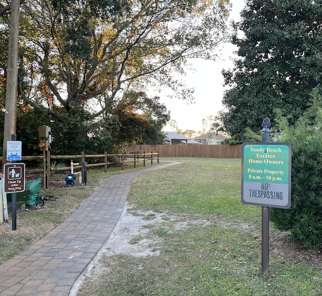 view of property's community with a yard and fence