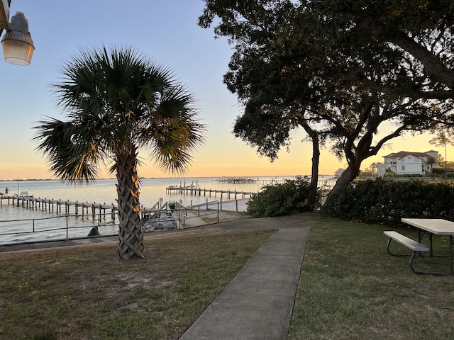 view of home's community featuring a water view, a yard, and fence