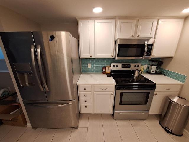 kitchen with decorative backsplash, white cabinetry, and stainless steel appliances