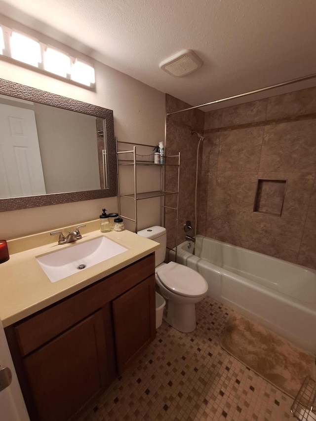 full bathroom featuring tile patterned floors, a textured ceiling, toilet, vanity, and tiled shower / bath