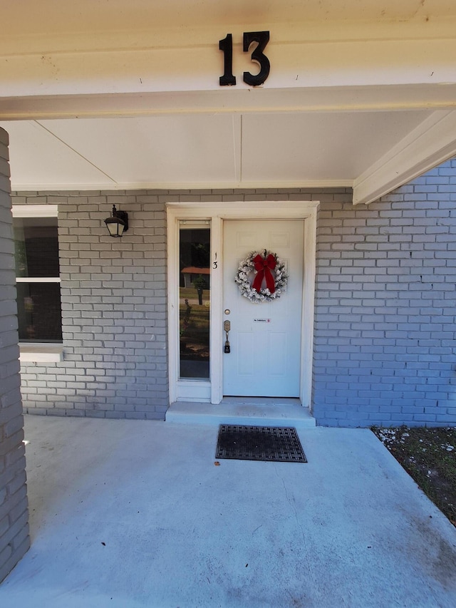 entrance to property featuring brick siding