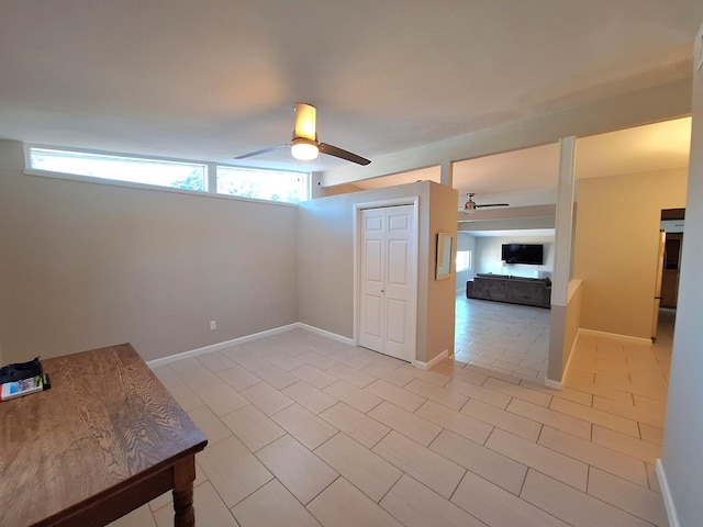 unfurnished room featuring a ceiling fan, plenty of natural light, and baseboards