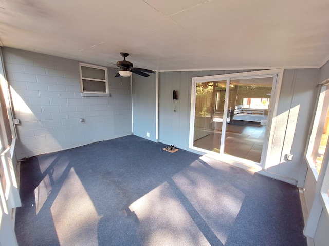 unfurnished sunroom featuring a ceiling fan