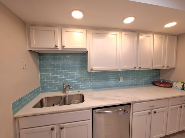 kitchen featuring tasteful backsplash, white cabinetry, a sink, and stainless steel dishwasher