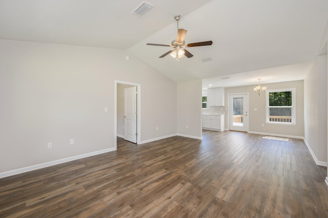 unfurnished living room with lofted ceiling, ceiling fan with notable chandelier, and dark hardwood / wood-style flooring