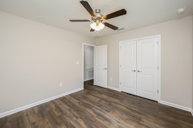 unfurnished bedroom with a closet, ceiling fan, and dark hardwood / wood-style flooring