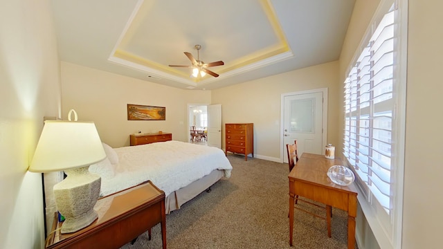 bedroom with ceiling fan, carpet floors, and a tray ceiling