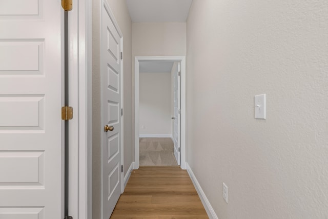 corridor with light hardwood / wood-style floors