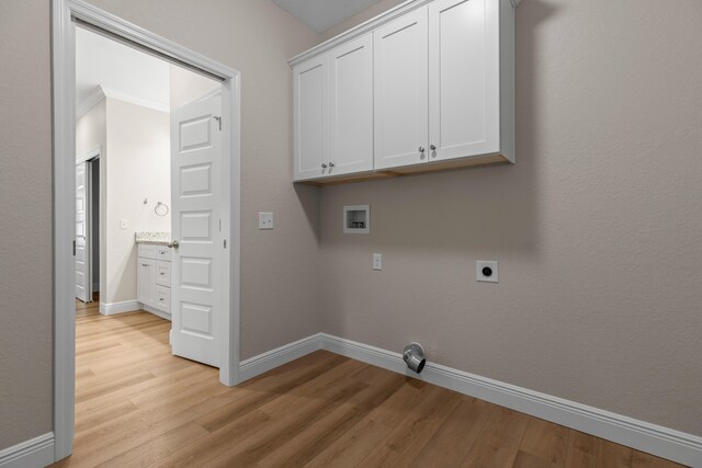 clothes washing area with cabinets, hookup for a washing machine, light hardwood / wood-style flooring, and hookup for an electric dryer