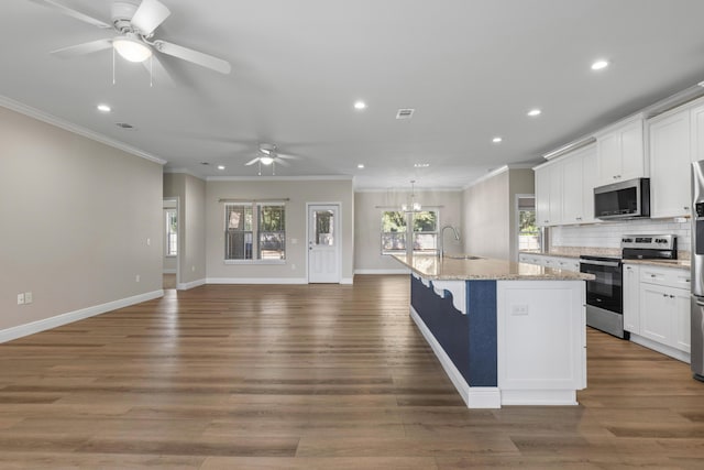 kitchen with stainless steel appliances, white cabinetry, a kitchen island with sink, and sink